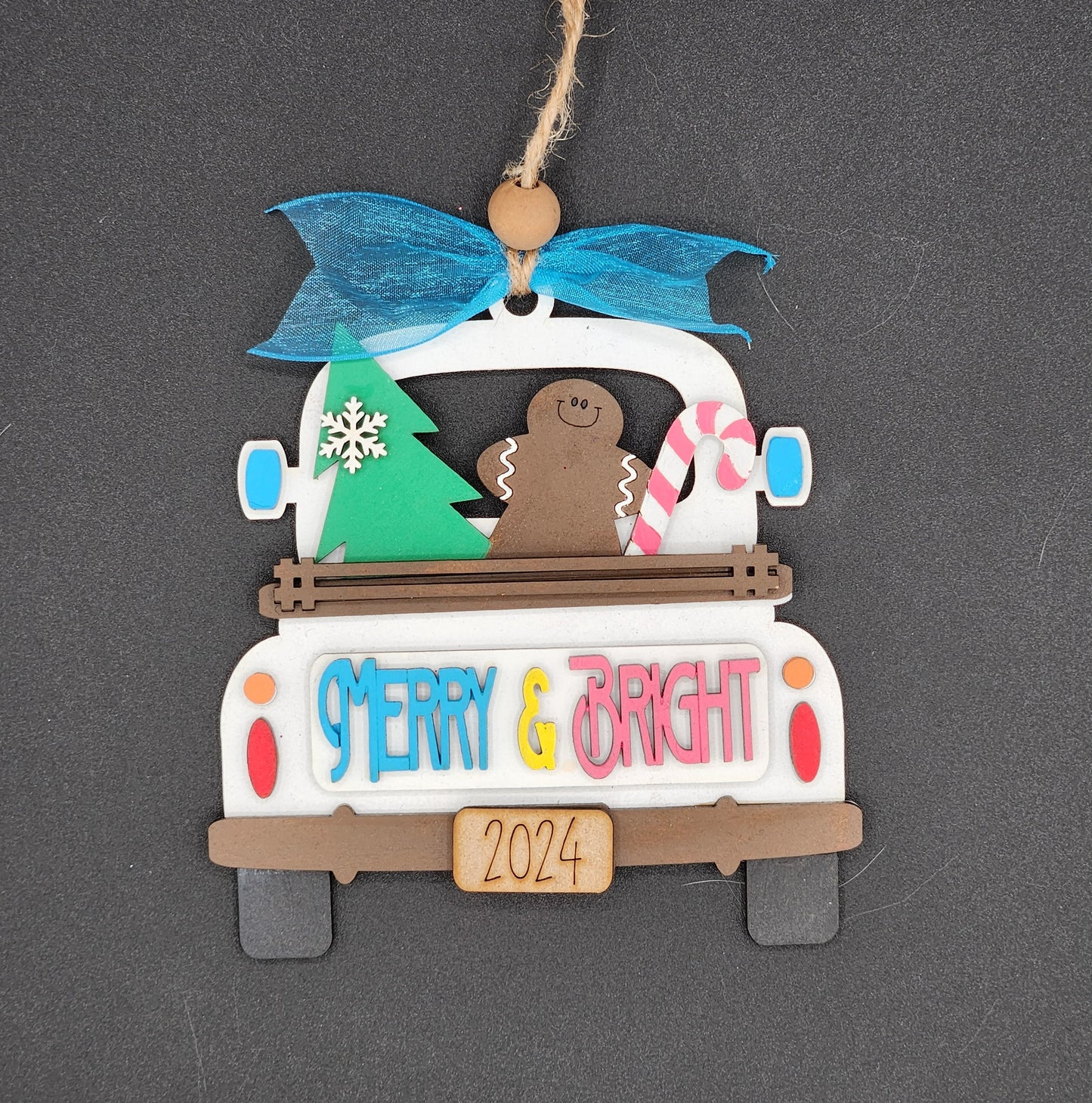 A craft kit to make a decorative truck ornament with 'Merry & Bright' text and a gingerbread man figure in the back window.