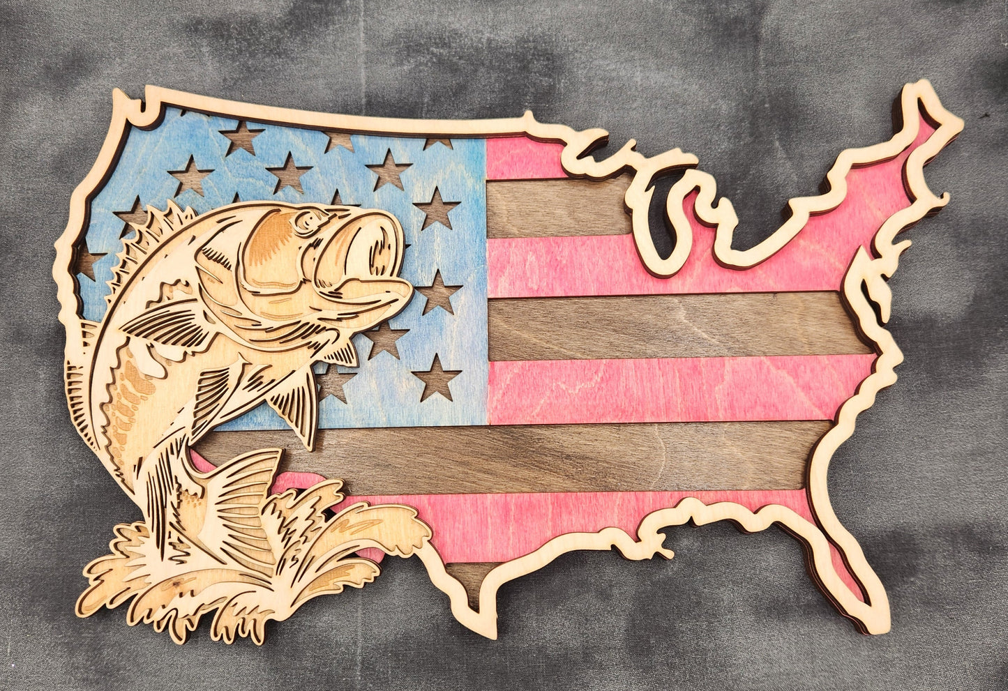 Decorative emblem with fish and striped design on a dark fabric background