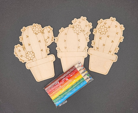 Three wooden cactus plant crafts intended for coloring, accompanied by a set of six small colored pencils.