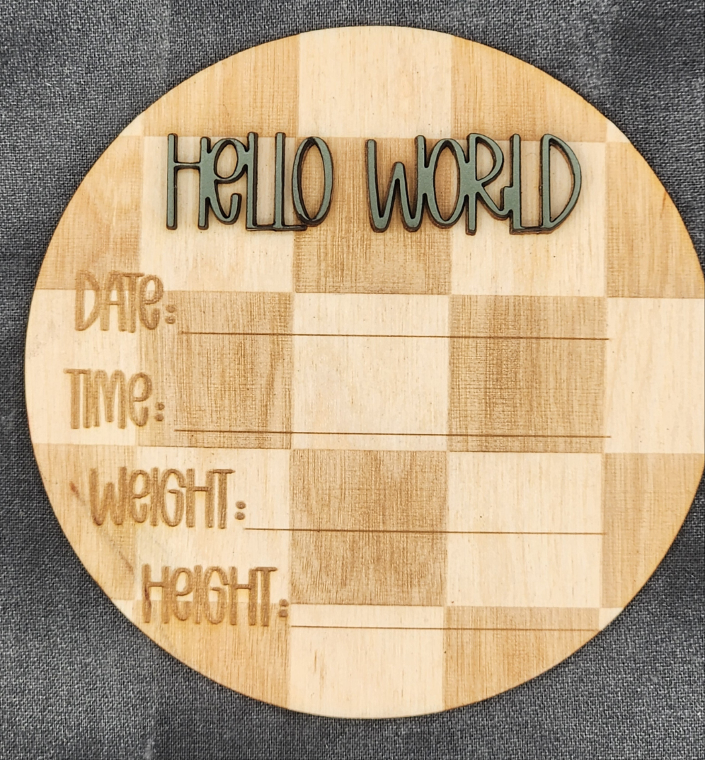 Round wooden board with engraved text 'HELLO WORLD' and placeholders for date, time, weight, and height on a dark background.