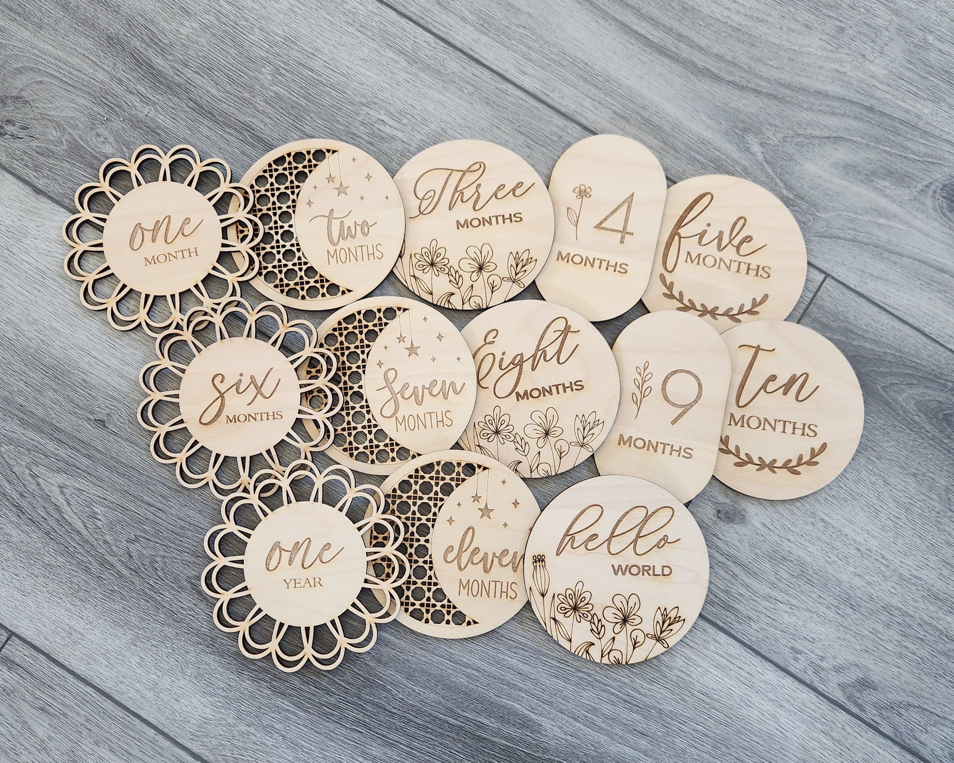 A collection of wooden discs with text and numbers on them, laid out on a wooden surface. Each disc has a different number ranging from 1 to 11 months.